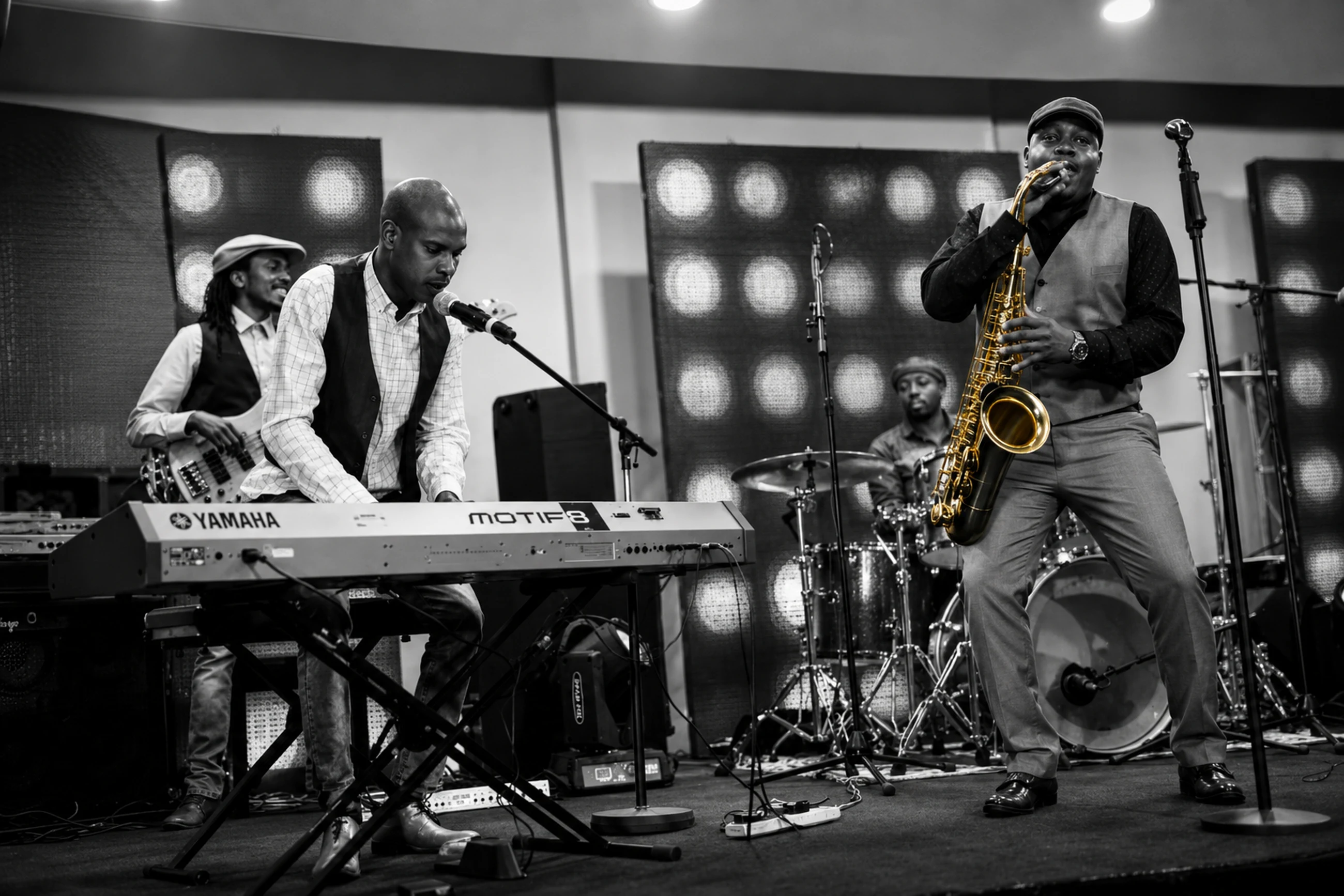 Different Faces Band on stage — keys, bass, drums and saxophone