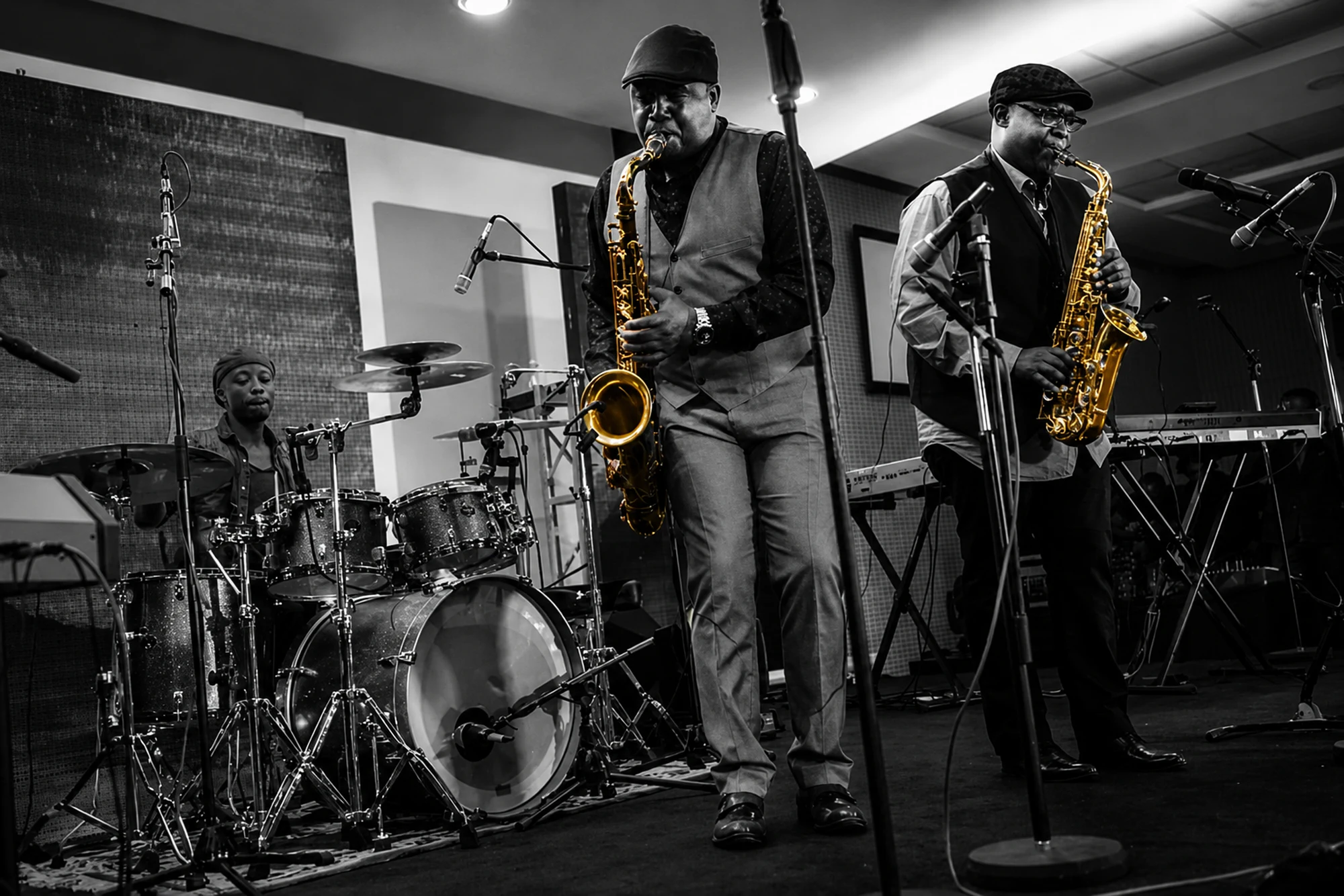 Wide view of Different Faces Band on a club stage