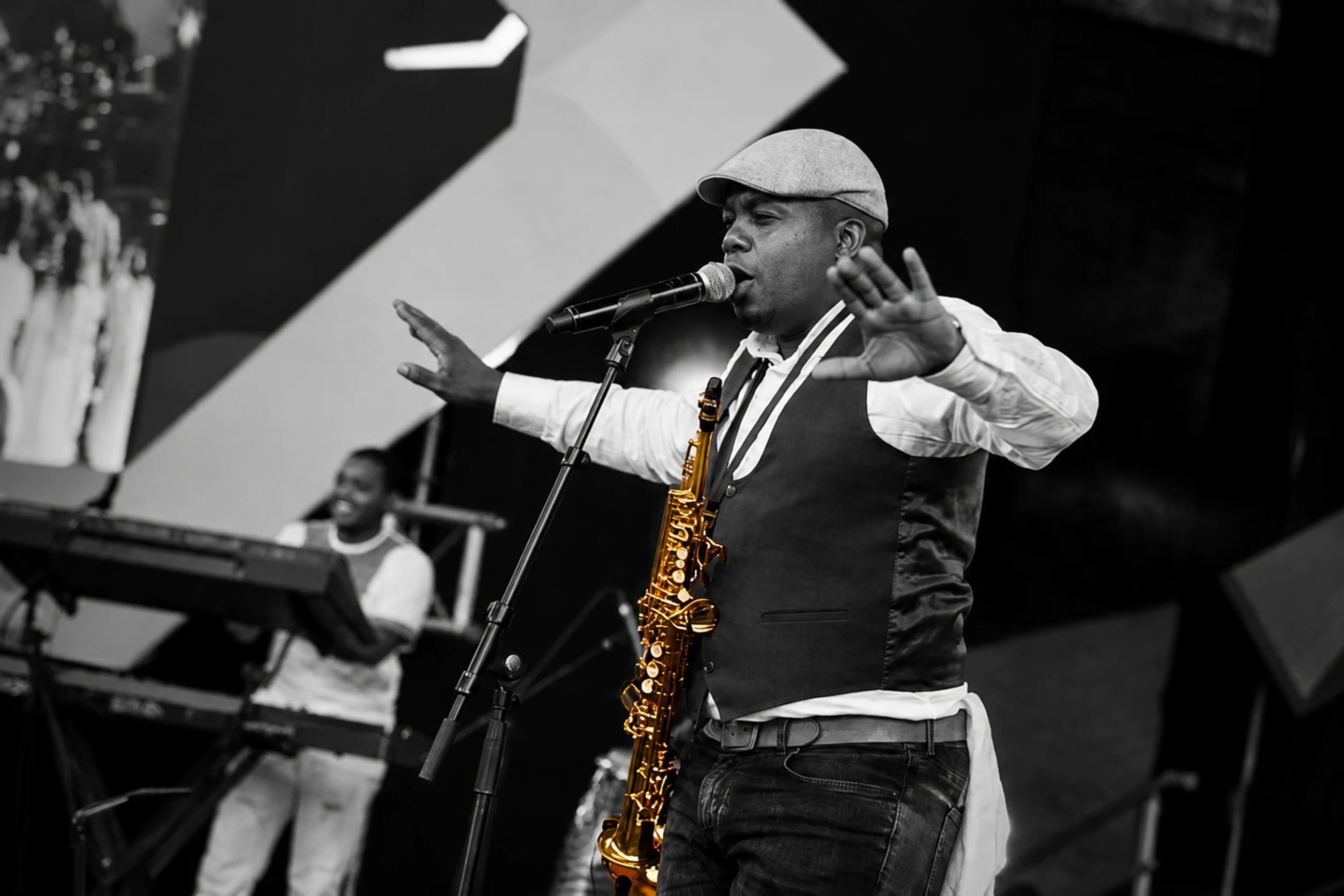Edward Parseen addressing a festival crowd, saxophone at his side