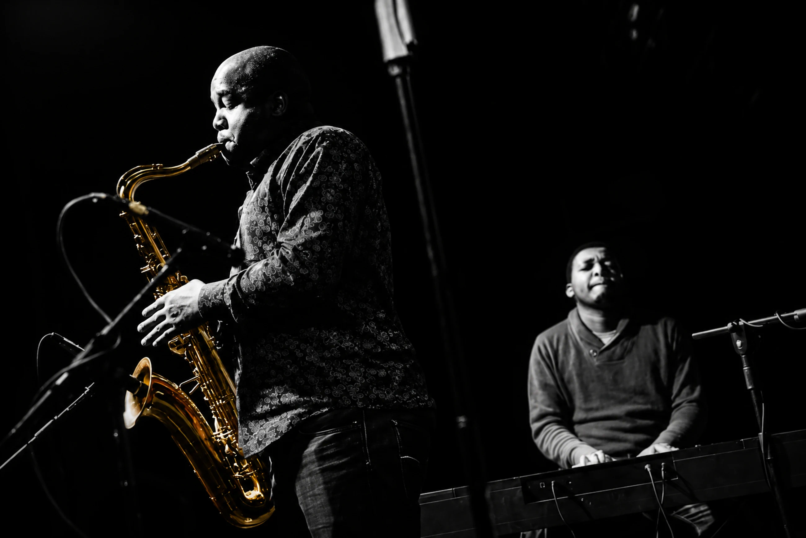 Edward Parseen playing alongside a pianist in a darkened room