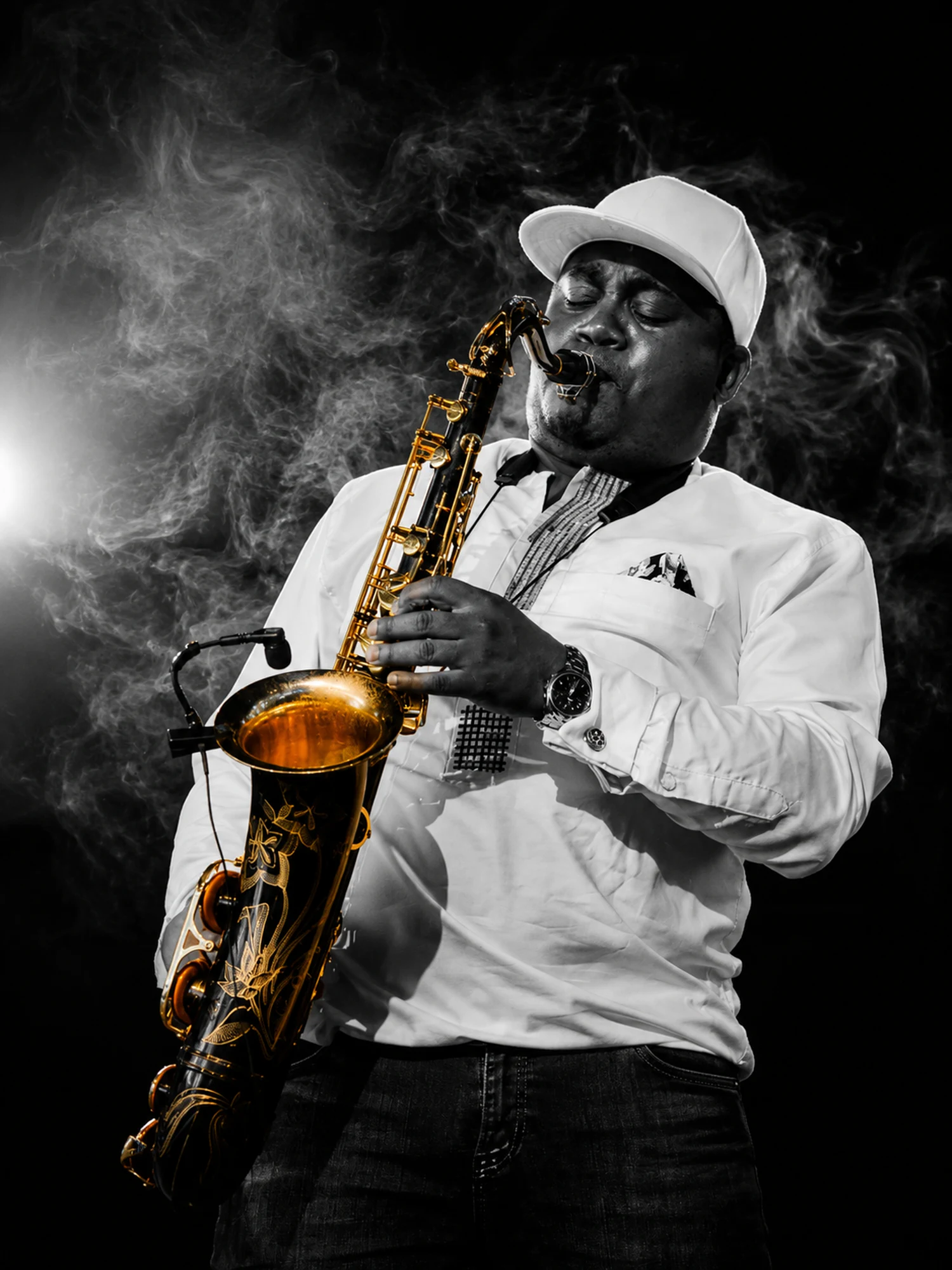 Edward Parseen in a white cap, backlit by smoke and a hard spotlight
