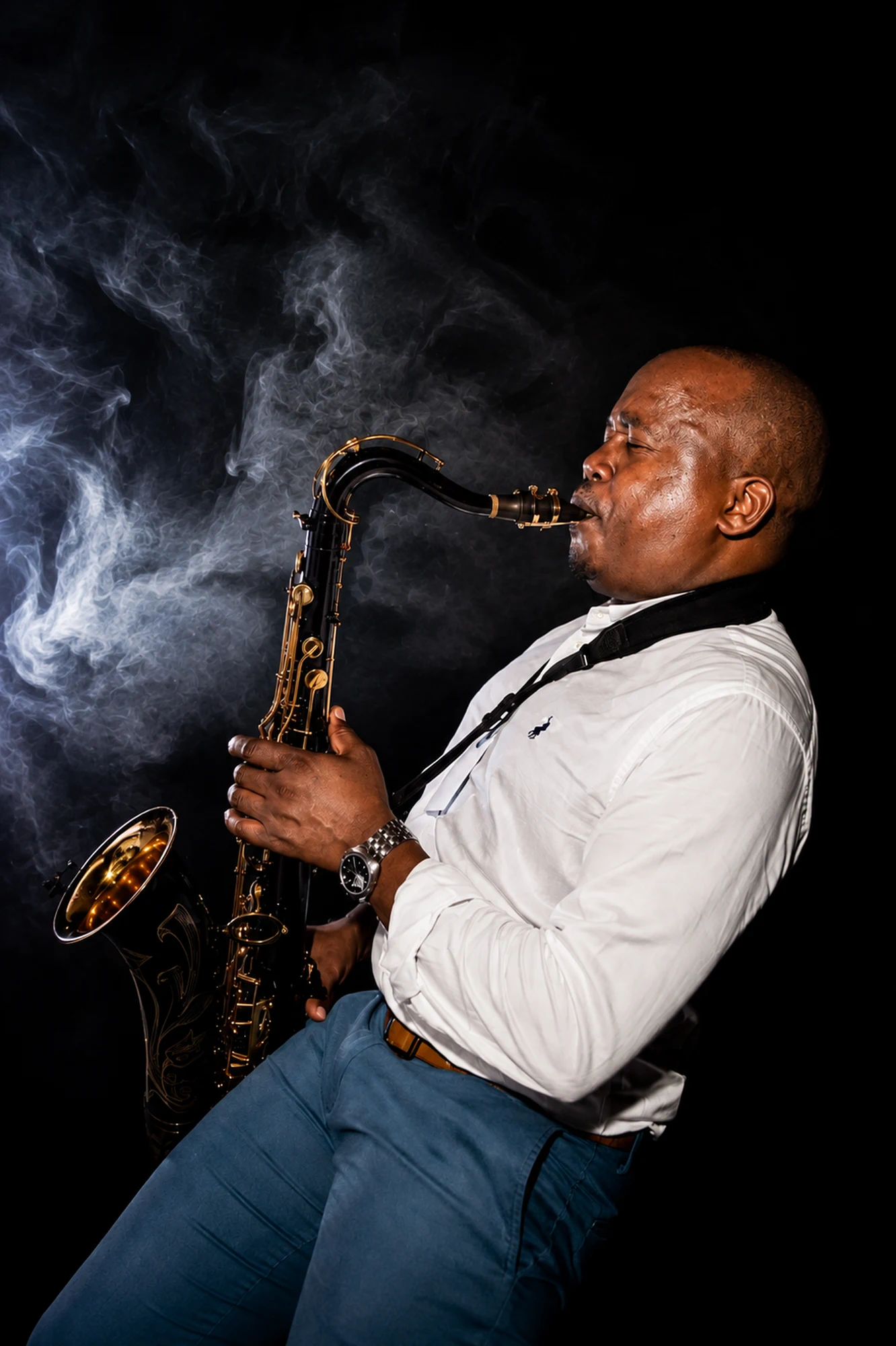 Full-length studio portrait of Edward Parseen playing, framed in smoke